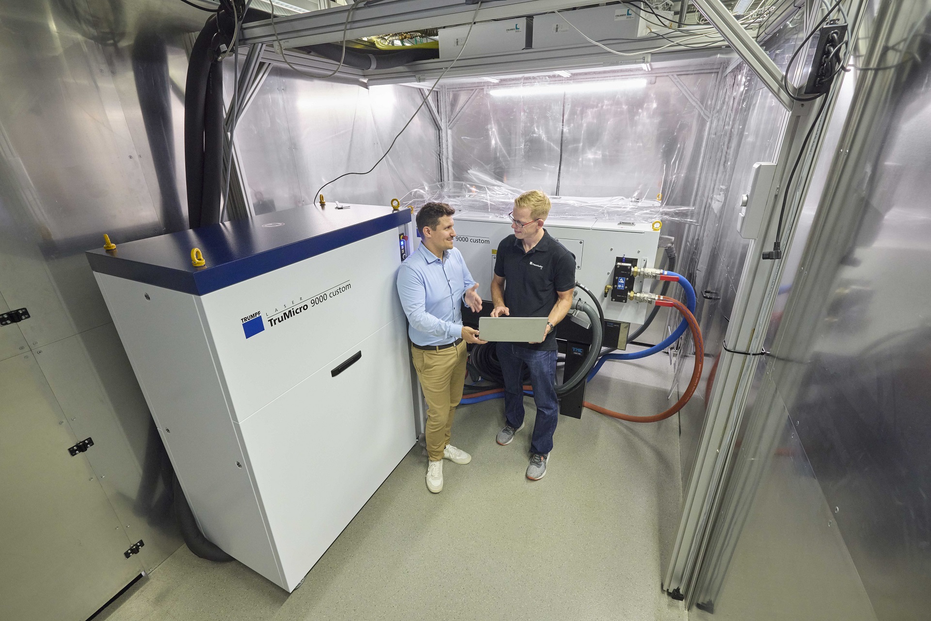 Steffen Rübling, TRUMPF (left), and Dr. Dennis Haasler, Fraunhofer ILT, discuss details of operating the 1 kW USP laser from TRUMPF.  