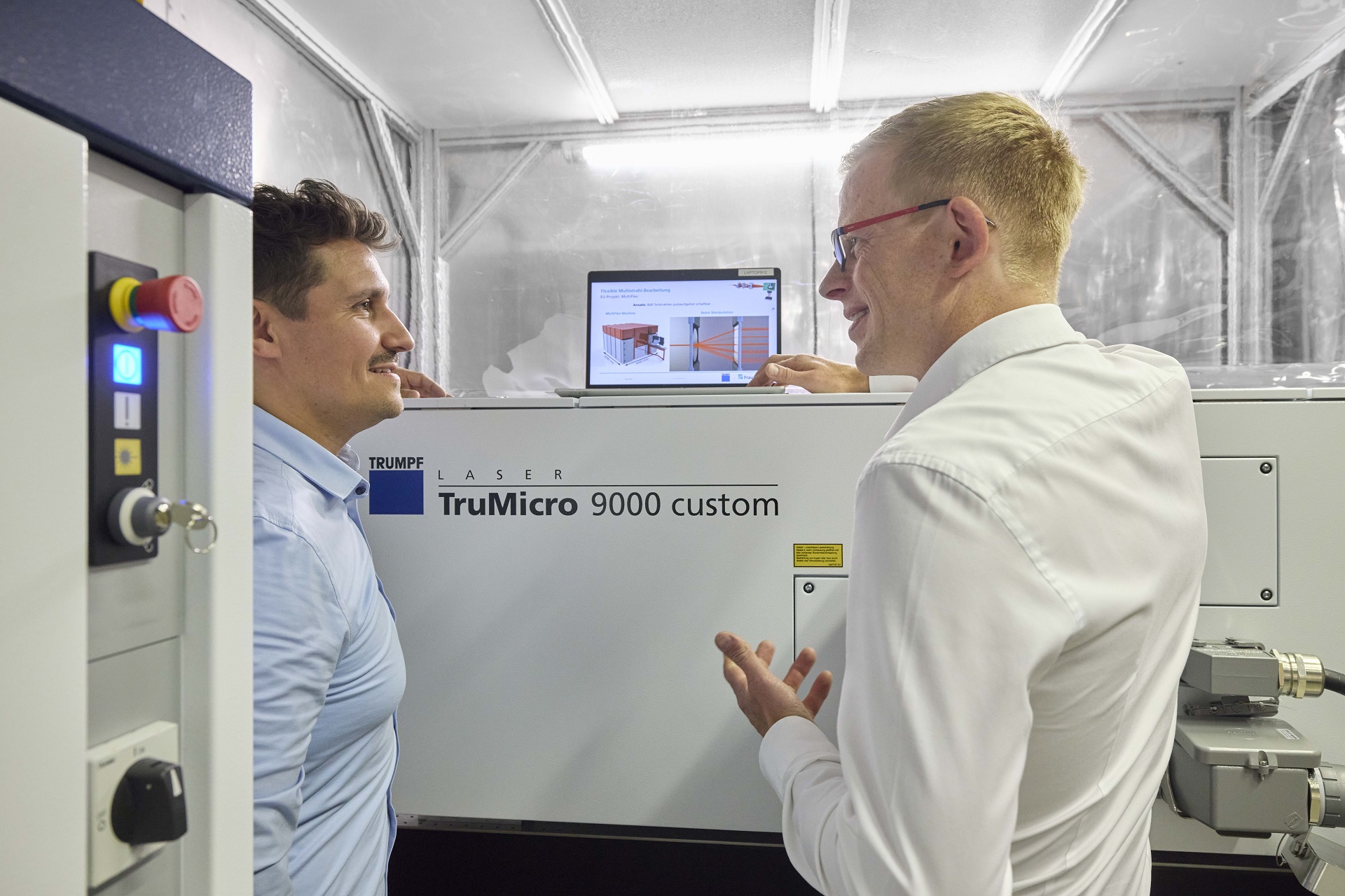 Steffen Rübling, TRUMPF (left), and Dr. Dennis Haasler, Fraunhofer ILT, discuss details of operating the 1 kW USP laser from TRUMPF.